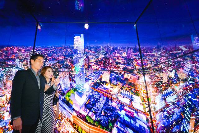 LG전자가 태국 최고층 건물인 마하나콘타워의 전망대 전용 엘리베이터에 설치한 ‘올레드 사이니지’를 통해 탑승객들이 방콕의 모습을 감상하고 있다. LG전자는 엘리베이터 2대에 55인치 올레드 사이니지 56장을 투입해 가상현실(VR) 공간에 들어온 듯한 몰입감을 선사한다. /사진제공=LG전자
