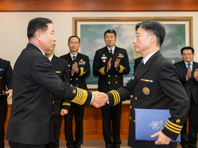 3일 해군 재경근무지원대대에서 열린 아주대학교 권역외상센터장 이국종 교수 명예해군 중령 임명식에서 심승섭 해군참모총장(왼쪽)이 이국종 교수에게 명예해군 중령 임명장을 수여한 뒤 악수하고 있다. /연합뉴스