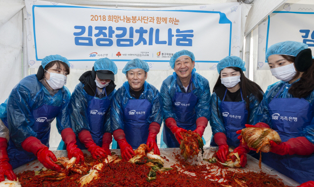 최근 서울 중구 한빛광장에서 열린 ‘사랑의 김장김치나눔’ 행사에서 정진문(왼쪽 세번째), 임진구(〃네번째) SBI저축은행 대표가 김장을 담그고 있다. 이날 SBI희망나눔봉사단은 직접 담근 김장 8,000포기를 중구 관내의 소외계층 1,650가구에 전달했다./사진제공=SBI저축은행