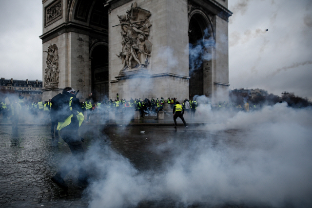 지난 1일(현지시간) 프랑스 파리의 개선문 주위에서 ‘노란 조끼’ 시위대가 최루가스를 터뜨리며 진압에 나선 경찰과 충돌하고 있다. / 파리 AFP=연합뉴스