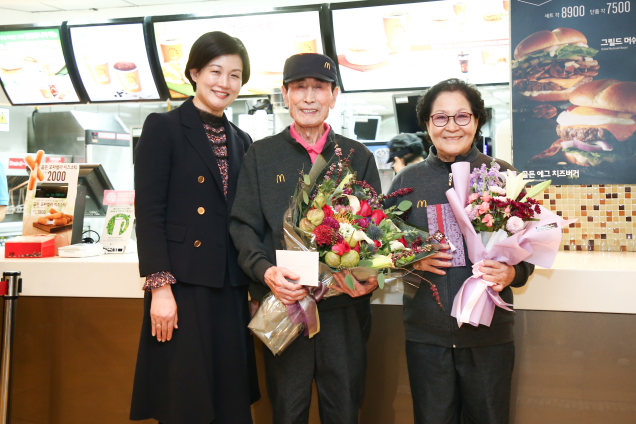 한국맥도날드의 최고령 시니어 크루인 임갑지(가운데)씨가 구순을 맞아 조주연(왼쪽) 한국맥도날드 사장으로부터 축하를 받은 후 아내 최정례씨와 함께 기념촬영을 하고 있다. /사진제공=한국맥도날드