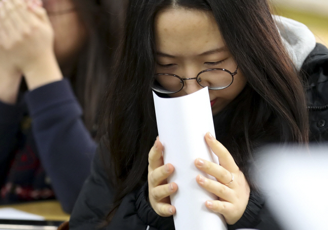 5일 오전 서울 여의도여자고등학교에서 성적표를 받아든 학생이 조심스레 확인하고 있다. /연합뉴스