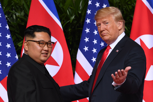 김정은(왼쪽) 북한 국무위원장과 도널드 트럼프 미국 대통령이 올해 6월 싱가포르에서 열린 북미 정상회담에서 기념촬영을 하고 있다. /AFP연합뉴스
