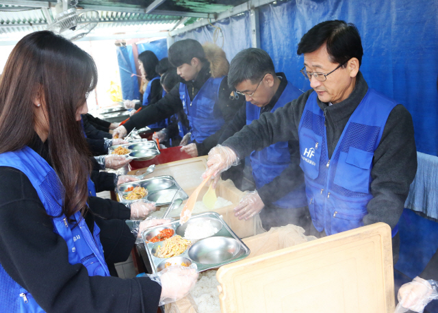 이정환(오른쪽) 한국주택금융공사 사장과 보금자리봉사단이 6일 부산 동구 부산진역 무료급식소에서 무료급식 봉사활동을 하고 있다./사진제공=주금공