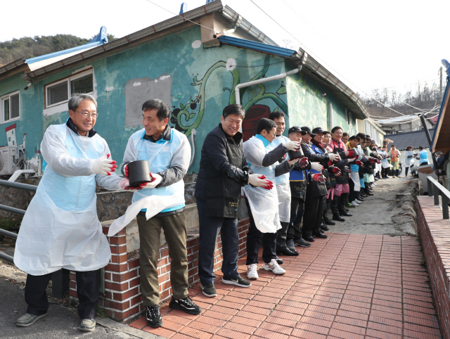 위성백(왼쪽 두번째) 예금보험공사 사장이 임직원·노조와 함께 6일 서울 서대문구의 한 국가유공자 가정 앞에서 연탄을 나르고 있다./사진제공=예보