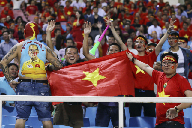 베트남 축구팬들이 지난 6일 스즈키컵 준결승 2차전에서 열띤 응원을 펼치고 있다. 등에 박항서 감독과 태극기를 그려넣은 열성팬(왼쪽)의 모습도 보인다.  /하노이=AP연합뉴스