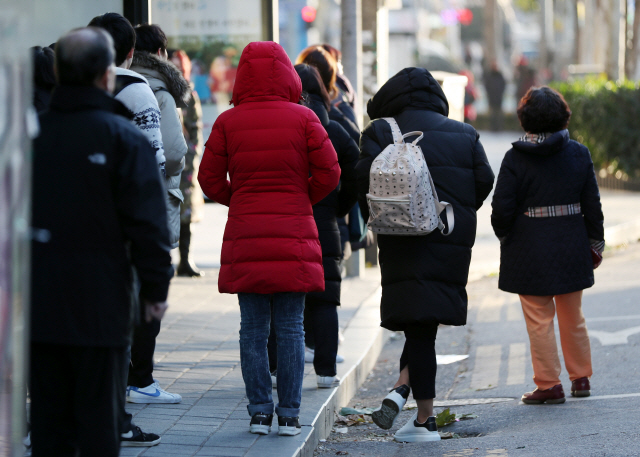 인천 일부 지역에 강풍주의보와 한파주의보가 발효된 7일 오전 인천시 남동구 구월동 한 버스정류장에서 시민들이 몸을 웅크리며 버스를 기다리고 있다. / 연합뉴스