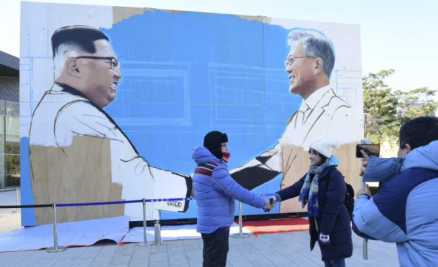 김정은 북한 국무위원장의 연내 서울답방을 둘러싼 온갖 추측이 난무하는 가운데 9일 오후 서울 종로구 청와대 앞 사랑채 부근에 문재인 대통령과 김 북한 국무위원장이 악수하는 모습을 그린 작품을 배경으로 외국인 관광객들이 기념 사진을 촬영하고 있다./송은석기자