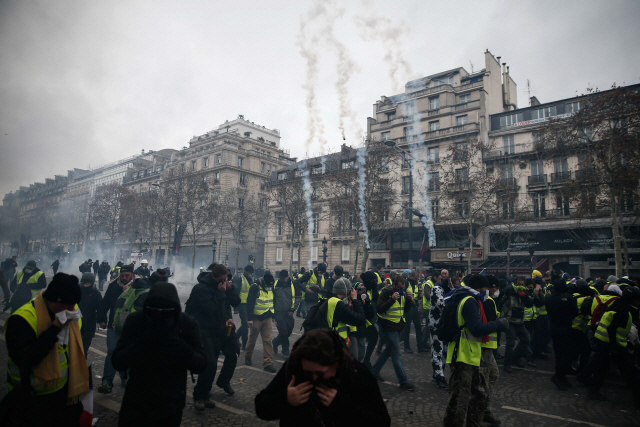 경찰이 쏜 최루탄에 괴로워 하고 있는 프랑스의 ‘노란 조끼’(Gilets Jaunes) 시위대./사진=AFP