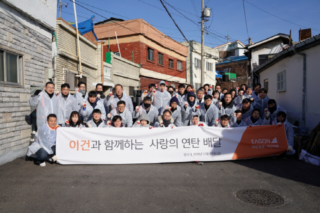 이건 관계사 임직원 60여 명이 7일 인천 미추홀구 숭의동에서 ‘사랑의 연탄 배달’ 봉사 활동을 진행한 후 기념촬영을 하고 있다. /사진제공=이건산업