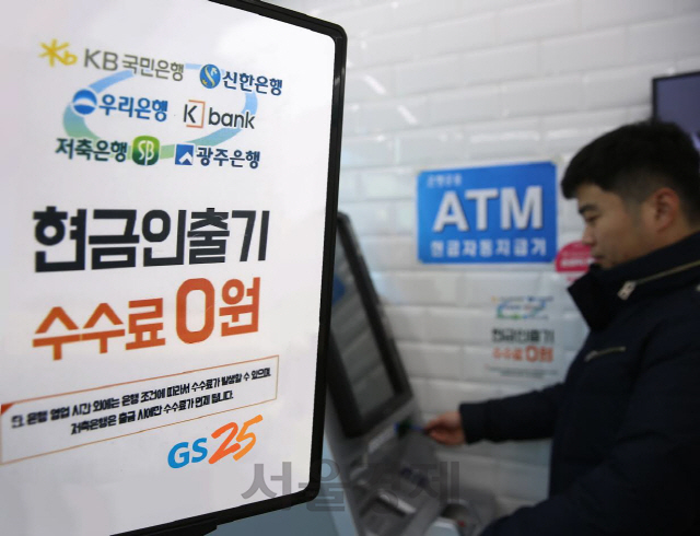 한 고객이 편의점 GS25 매장에 설치된 현금자동입출금기(ATM)를 이용하고 있다. /사진제공=GS리테일