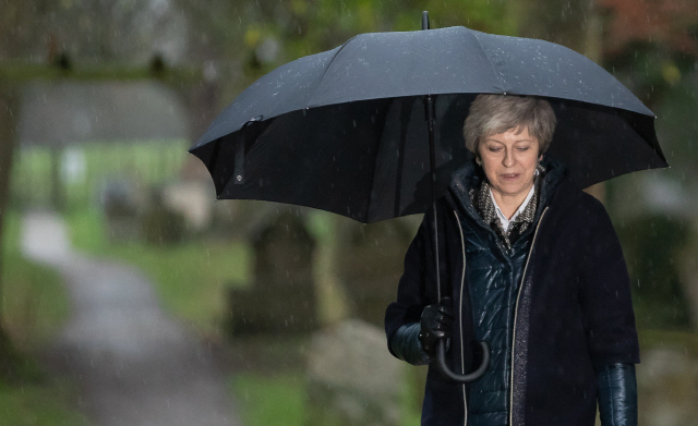 테리사 메이 영국 총리가 9일(현지시간) 런던의 한 교회에서 예배를 마친 뒤 우산을 들고 빗속을 걸어가고 있다. /런던=AFP연합뉴스