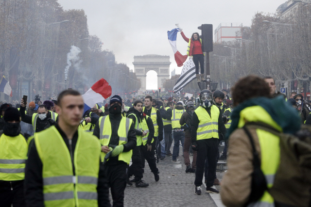 ‘노란 조끼’를 입은 시위대가 지난달 24일 프랑스 파리 개선문 앞에 모여 항의시위를 벌이고 있다. /파리=AP연합뉴스
