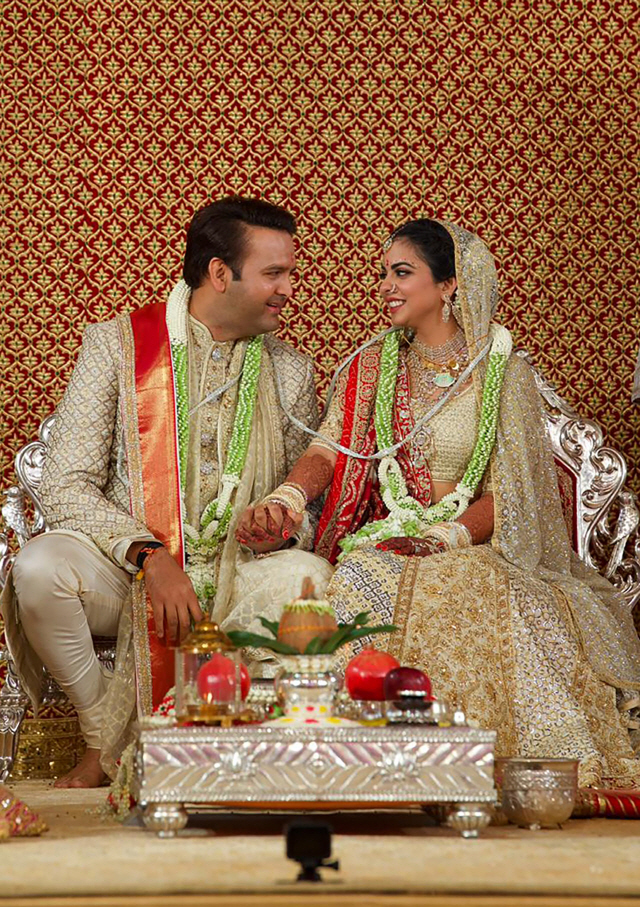 아시아 최대갑부인 무케시 암바니 릴라이언스그룹 회장의 딸 이샤 암바니가 12일(현지시간) 인도 뭄바이에서 치러진 결혼식에서 신랑과 나란히 앉아 마주 보고 있다. 최대 1억달러(약 1,130억원)가 들어간 이번 결혼식에 힐러리 클린턴 전 미 국무장관 등 세계 정재계 거물은 물론 한국에서 이재용 삼성 부회장도 참석해 눈길을 끌었다.    /뭄바이=AFP연합뉴스