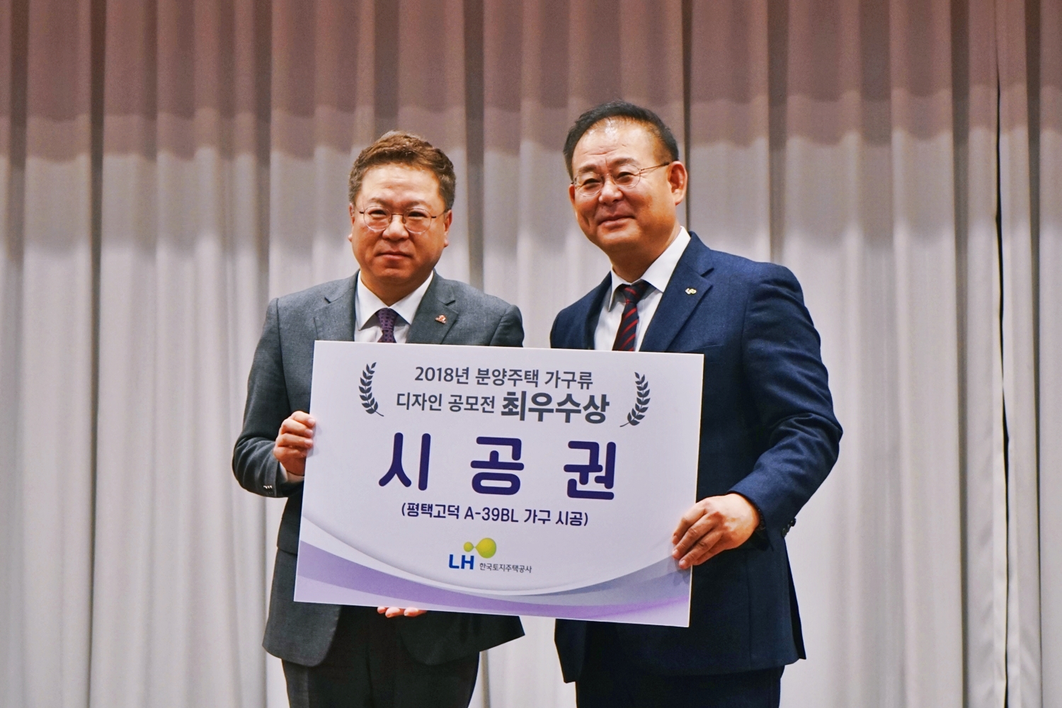 지난 13일 열린 ‘LH 가구디자인 공모전’ 시상식에서 넵스 김범수 대표(왼쪽)와 LH 김한섭 공공주택본부장(오른쪽)이 기념촬영을 하고 있다.