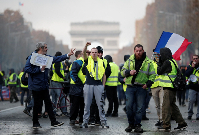 프랑스의 고유가 정책에 반발한 ‘노란조끼’ 시위대가 지난달 24일(현지시간) 파리 샹젤리제 거리에서 정부 정책에 항의하는 시위를 벌이고 있다. /로이터연합뉴스
