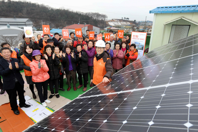 지난 13일 충북 음성군 봉곡2리 마을회관에서 열린 해피선샤인 캠페인 설비 준공식에서 한화그룹 관계자들과 마을 주민들이 기념촬영을 하고 있다. /사진제공=한화그룹