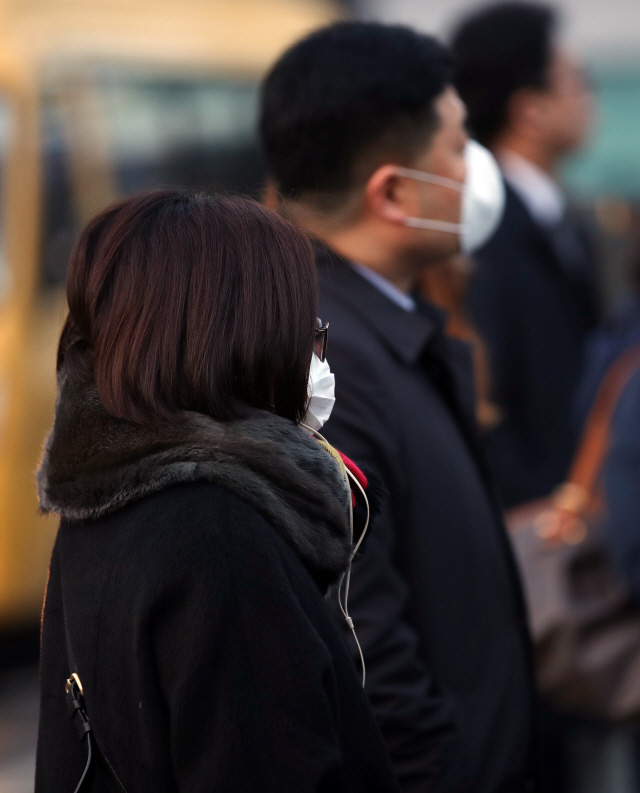 17일 오전 서울 종로구 광화문 세종대로 사거리에서 마스크를 쓴 출근길 시민들이 발걸음을 옮기고 있다. 국립환경과학원 대기질통합예보센터는 18일도 미세먼지가 ‘나쁨’ 수준을 보일 것으로 예보했다. / 연합뉴스
