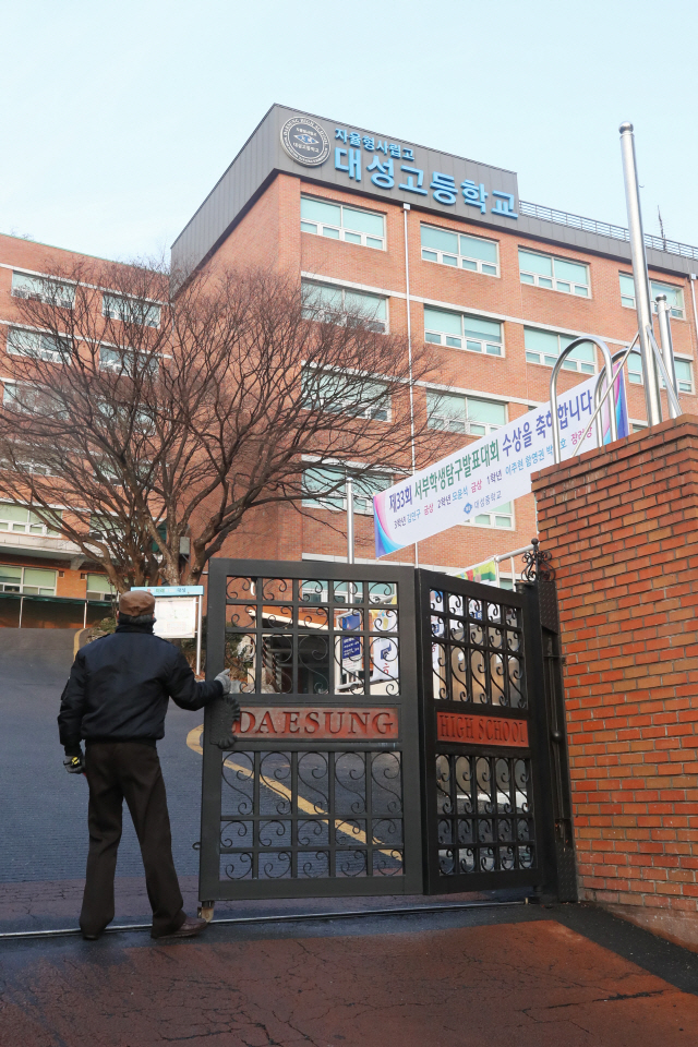 강릉 펜션 사고로 사상한 10명의 학생이 재학 중이던 서울 은평구 대성고등학교가 사흘간의 임시휴업에 들어갔다. 19일 오전 학교 경비원이 교문을 닫고 있다. / 연합뉴스