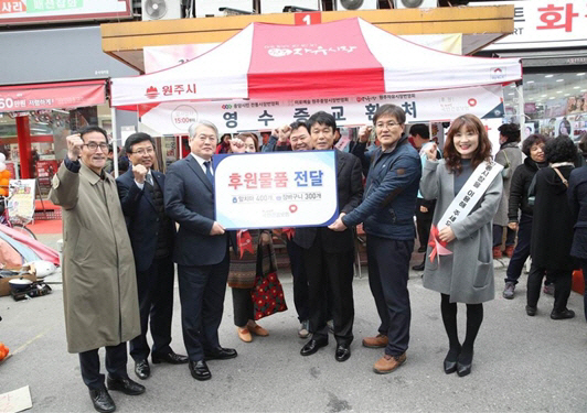 지난달 19일 김용익(왼쪽 세번째) 국민건강보험공단 이사장이 강원 원주시 중앙동의 원주자유시장을 방문해 상인들에게 후원물품을 전달하고 있다. /사진제공=국민건강보험공단