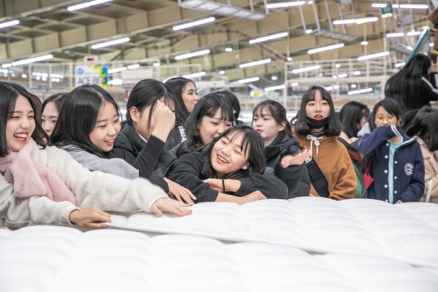 충북 음성에 자리한 에이스침대 생산공장과 침대공학연구소를 방문한 학생들이 매트리스와 스프링을 직접 만져보며 웃고 있다. .  /사진제공=에이스침대