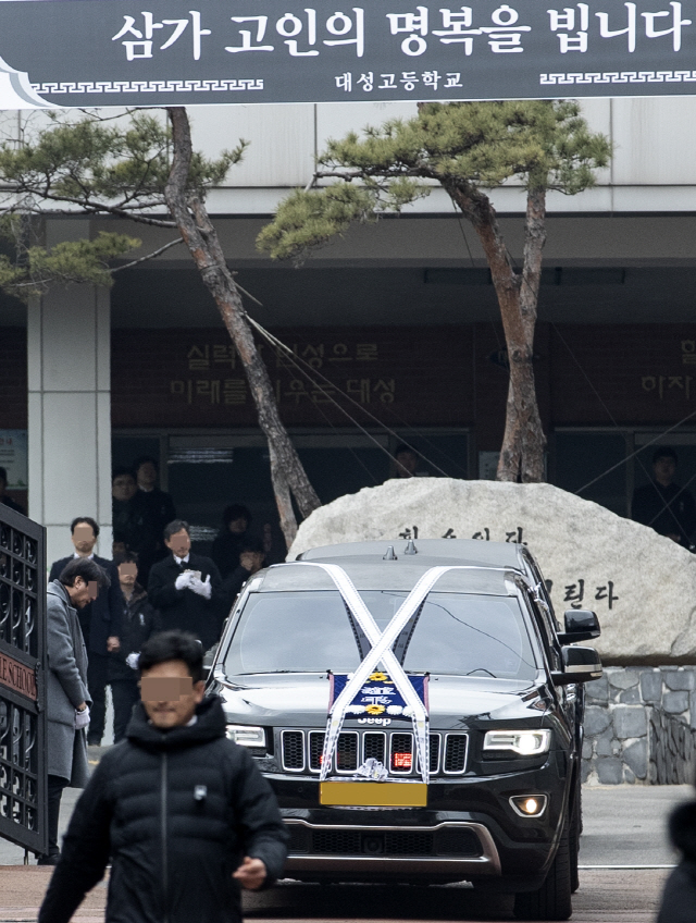 강릉 펜션사고로 세상을 떠난 서울대성고등학교 학생들의 발인이 엄수된 21일 오후 작별 인사를 마친 운구차량이 서울 은평구 대성고등학교를 나서고 있다./연합뉴스