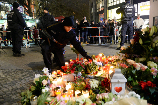 독일 베를린에서 지난 2016년 12월 20일(현지시간) 한 경찰관이 전날 발생한 트럭 테러사건의 희생자들을 추모하고 있다. /베를린=EPA연합뉴스