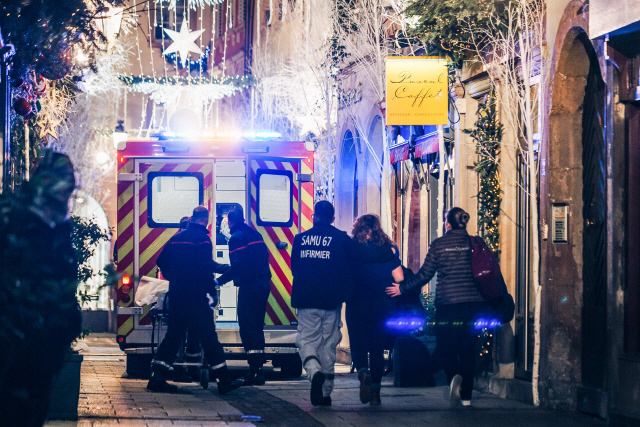 11일(현지시간) 총격사건으로 15명의 사상자가 발생한 프랑스 동부 스트라스부르의 크리스마스 시장에서 경찰과 소방대원들이 피해자를 병원으로 이송하고 시민들을 대피시키고 있다.  /스트라스부르=AFP연합뉴스