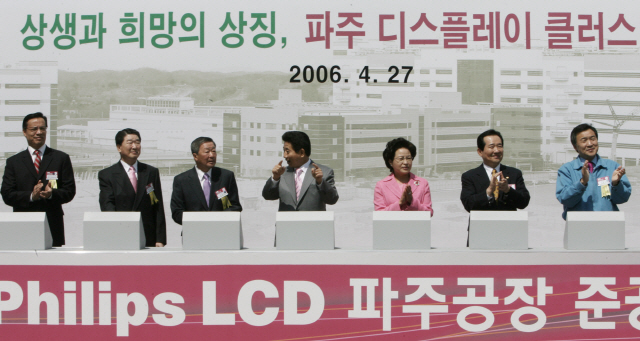 지난 2006년 4월 고(故) 노무현 대통령이 LG필립스 LCD 파주공장 준공식에 참석해 정재계 관계자들과 터치 버튼을 누른 뒤 대화를 나누고 있다.  /연합뉴스