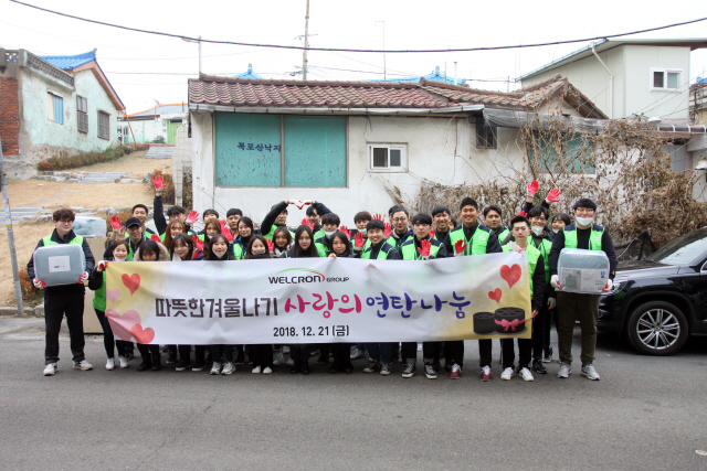 웰크론그룹 임직원들이 지난 21일 인천에 소재한 저소득층 밀집 지역을 찾아 연탄 3,000여장을 나르는 봉사활동을 벌인 뒤 기념촬영을 하고 있다. /사진제공=웰크론