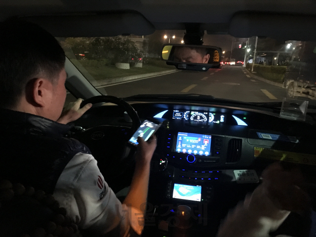 선전의 한 전기택시 운전자가 지난 20일(현지시간) 스마트폰으로 목적지를 확인하고 있다. /광저우=김창영기자
