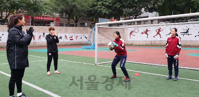 현대제철 레드엔젤스의 국가대표 골키퍼 김정미 선수(왼쪽)가 따핑중학교 선수들을 지도하며 즐거워하고 있다./사진제공=현대제철