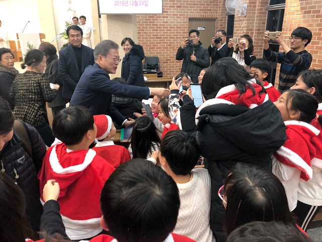 문재인 대통령이 24일 경남 양산 덕계성당에서 열린 성탄전야 미사에 참석해 아이들과 인사를 나누고 있다. /사진제공=청와대