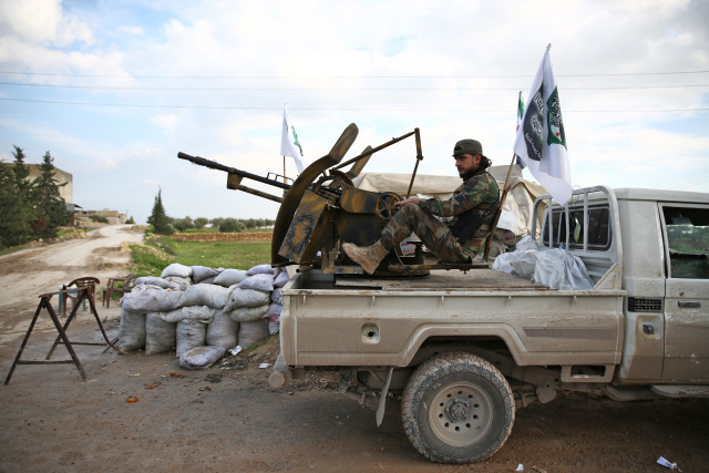 터키 정부의 지원을 받는 시리아군 군인이 24일(현지시간) 쿠르드계 반란군이 점령한 시리아 카라블루스 인근 크라타에서 기관총이 장착된 트럭 위에 앉아 있다. /크라타=AFP연합뉴스