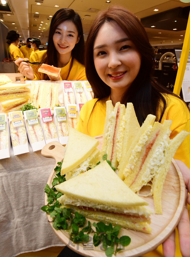 27일 서울 중구 롯데백화점에서 모델들이 '인기가요 샌드위치'를 선보이고 있다. '인기가요 샌드위치'는 한 방송사의 가요프로그램 녹화장소 매점에서 판매하는 제품으로 연예인들이 SNS에 올리면서 유명해졌다./권욱기자