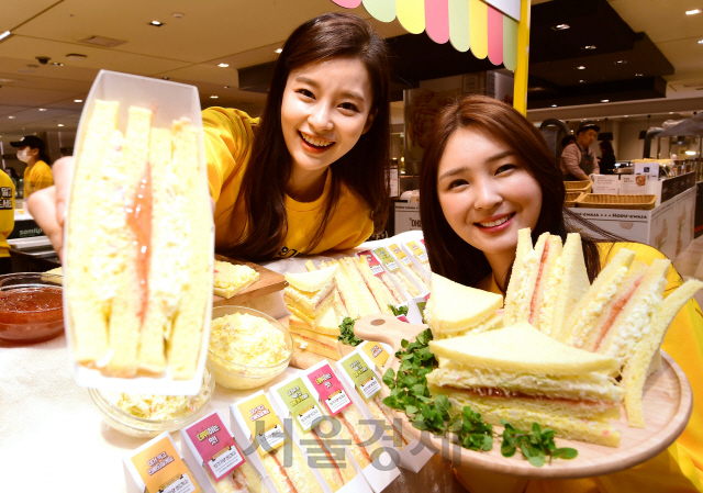 27일 서울 중구 롯데백화점에서 모델들이 '인기가요 샌드위치'를 선보이고 있다. '인기가요 샌드위치'는 한 방송사의 가요프로그램 녹화장소 매점에서 판매하는 제품으로 연예인들이 SNS에 올리면서 유명해졌다./권욱기자