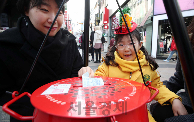 구세군이 자선냄비 모금을 시작한 30일 서울 명동 거리에서 시민들이 도움의 성금을 하고있다./서울경제DB