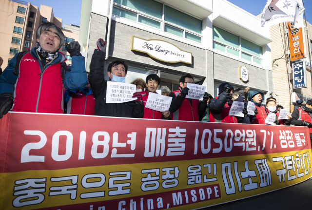 미소페 관련 제화공들이 27일 서울 성동구의 미소페 앞에서 회사를 규탄하는 구호를 외치고 있다. 미소페는 지난 26일 공장 중 한 곳을 중국으로 기습 이전한 것으로 알려졌다. /연합뉴스