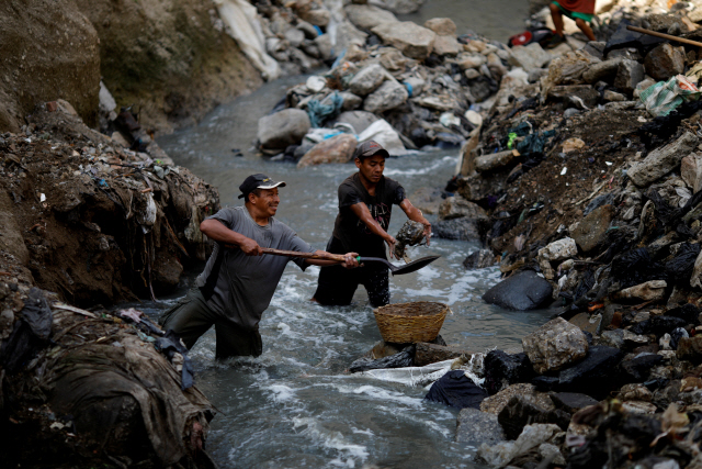 27일(현지시간) 과테말라에서 사람들이 쓰레기 더미 속에서 고철을 찾고있다. /로이터연합뉴스