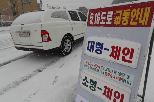 제주 산지에 대설주의보가 내려진 28일 오전 제주대 입구 사거리에서 체인이 없는 소형차량과 대형차량의 516도로 진입을 통제하고 있다. /연합뉴스