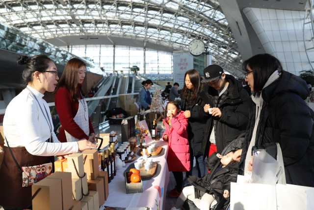 공항이용객들이 지난 29일 인천공항 제1터미널 교통센터에서 소상공인 제품을 시음하고 있다. 인천국제공항공사는 지난 28~29일 소상공인을 지원하기 위한 벼룩시장 행사인 ‘곳장 라이프 페어’를 개최했다고 30일 밝혔다. /사진제공=인천공항공사