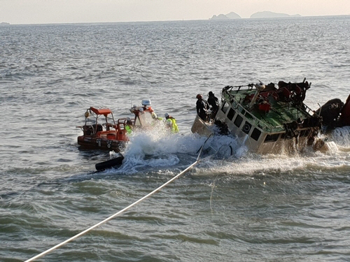 중앙해양특구조단 대원이 30일 충남 보령시 오천면 장고도 3km 해상에서 좌초된 예인선 J호에 올라 배에 남아있는 기름을 빼내기 위해 유류 호스를 연결하고 있다./사진=연합뉴스