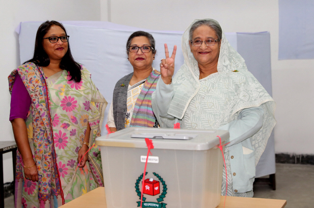 방글라데시 총선이 실시된 30일(현지시간) 수도 다카의 한 투표소에서 셰이크 하시나 방글라데시 총리(오른쪽)가 투표 후 손가락으로 승리의 브이(V)자를 만들어 보이고 있다. /다카=로이터연합뉴스