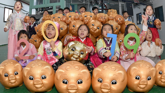 31일 경기도 파주 진인어린이집 아이들이 기해년 돼지해를 맞아 플라스틱 제조기업 성도테크를 방문해 황금돼지저금통을 들고 새해 소원을 외치고 있다.        /파주=이호재기자