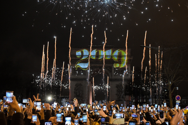 1일(현지시간) 프랑스 파리의 개선문 앞에 모인 시민들이 새해맞이 레이저쇼를 즐기고 있다. /파리=AFP연합뉴스