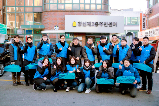 지난해 12월 31일 서울 종로구 창신2동 주민센터에서 열린 ‘사랑의 사과 배달식’에서 정원재(뒷줄 왼쪽 네번째) 우리카드 사장이 직원들과 기념사진을 촬영하고 있다./사진제공=우리카드