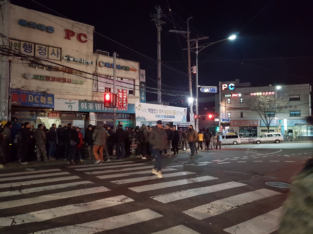 2일 서울 구로구 남구로역 사거리 하나은행 앞에서 일용직 근로자들이 일감을 기다리고 있다. 이들 앞에는 한 정당에서 걸어놓은 새해 축하 현수막이 걸려 있다. /심우일기자
