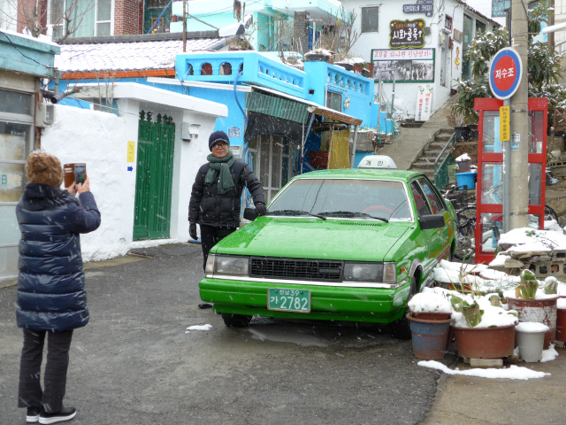 ‘연희네 슈퍼’를 찾은 방문객들이 슈퍼 앞에 전시된 택시 앞에서 사진을 찍고 있다.