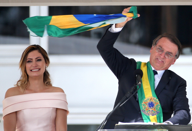 자이르 보우소나루(오른쪽) 브라질 대통령이 1일(현지시간) 취임식에서 국기를 흔들고 있다. /브라질리아=로이터연합뉴스