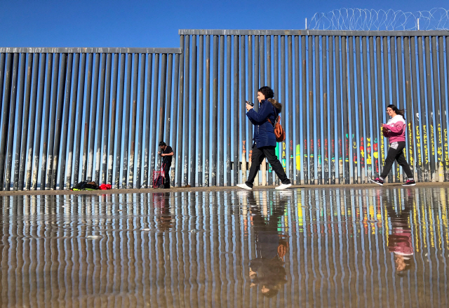 2일(현지시간) 미국과 국경지대인 멕시코 티후아나에서 사람들이 장벽을 지나가고 있다. /티후아나=로이터연합뉴스
